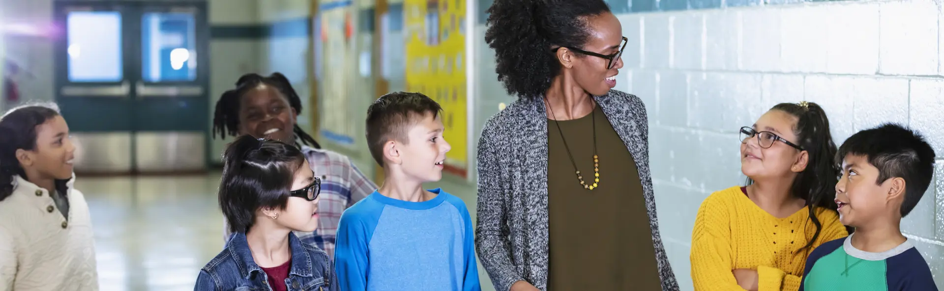 Teacher talking to students with hallway