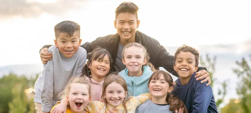 Group of children outside smiling at the camera.