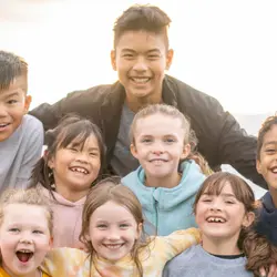 Group of children outside smiling at the camera.